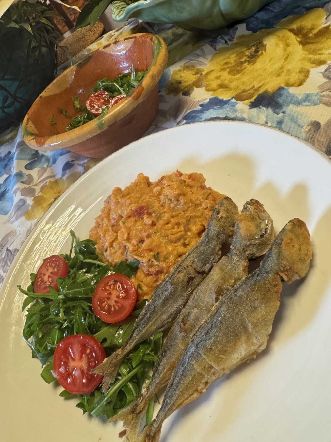 imagem com um prato com açorda de tomate, carapauzinhos fritos e uma salada de rúcula e tomate cherry